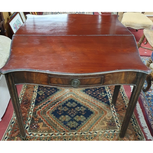 24 - A Georgian Mahogany serpentine fronted foldover Tea Table  with a frieze drawer with brass ring hand... 