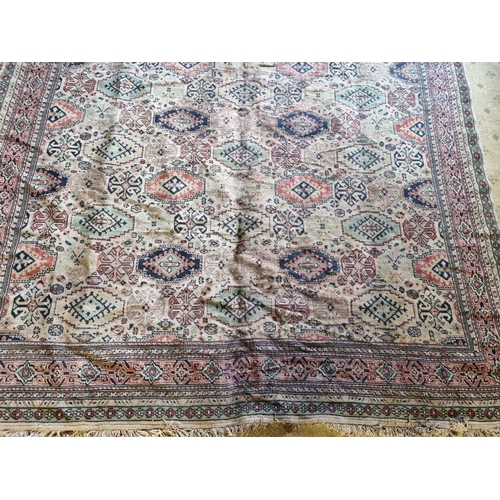 67 - A Large Middle Eastern Carpet with geometric design in neutral tones of brown, green and red, 320 x ... 