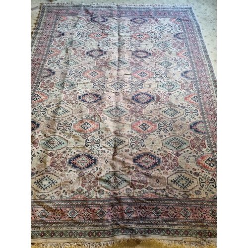 67 - A Large Middle Eastern Carpet with geometric design in neutral tones of brown, green and red, 320 x ... 