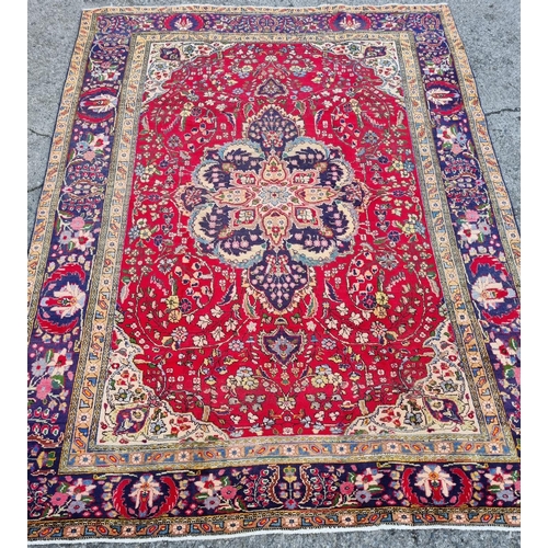 253 - A superb quality Red ground Tabriz Carpet with a central medallion design surrounded by a rich Blue ... 