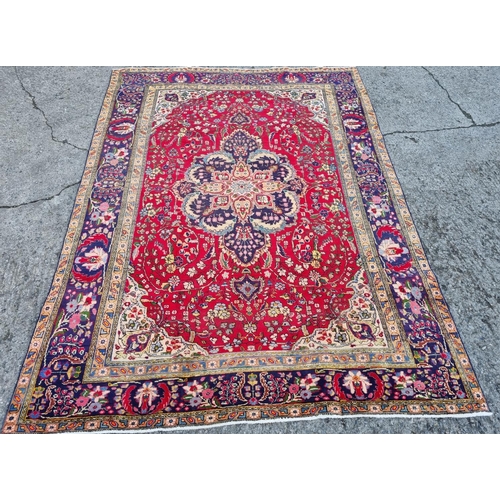 253 - A superb quality Red ground Tabriz Carpet with a central medallion design surrounded by a rich Blue ... 