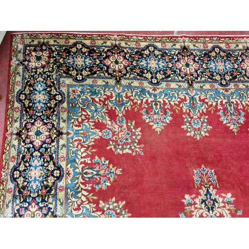 60 - A beautiful full pile red ground Persian Kerman Carpet with central medallion design and a floral bo... 