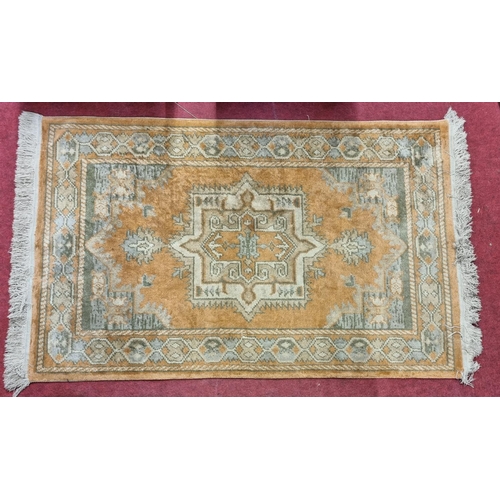196 - A salmon ground Rug with unique medallion design. L 154 x W 90 cm approx.