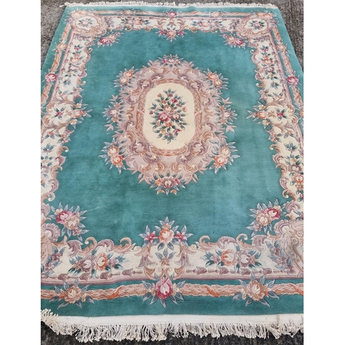294 - A Turquoise/Green ground Carpet with floral design and medallion centre. 370 x 230 cm approx.