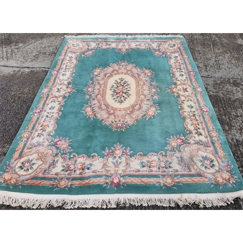 294 - A Turquoise/Green ground Carpet with floral design and medallion centre. 370 x 230 cm approx.