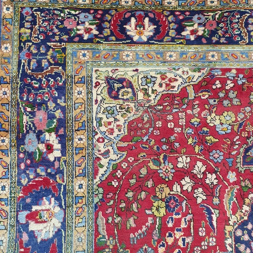 253 - A superb quality Red ground Tabriz Carpet with a central medallion design surrounded by a rich Blue ... 