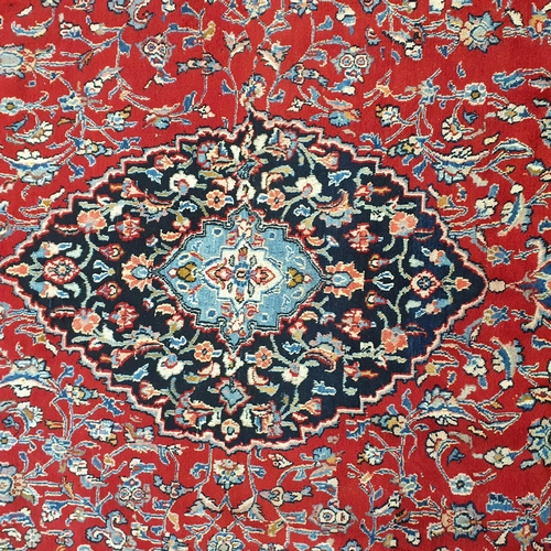 254 - A really good quality Red ground Persian Kashan Carpet with a traditional Kashan design with blue bo... 