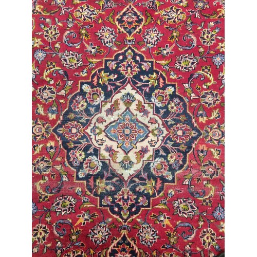 330 - A red ground Persian Rug with unique medallion design. 258 x 130 cms approx.