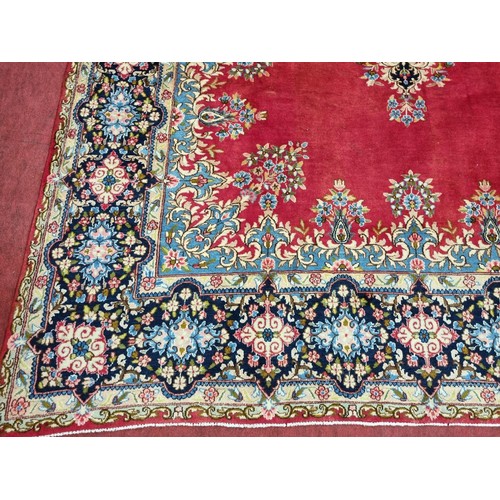 413 - A beautiful full pile red ground Persian Kerman Carpet with central medallion design and a floral bo... 