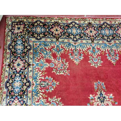 413 - A beautiful full pile red ground Persian Kerman Carpet with central medallion design and a floral bo... 