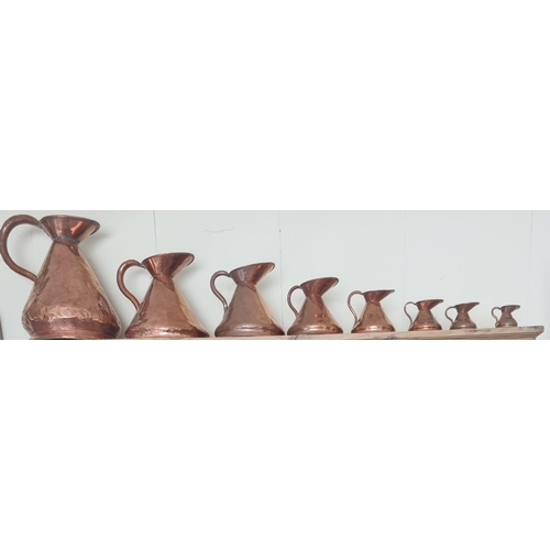 333 - A Fabolous set of eight 19th Century graduated Copper Measures from 1 gallon. Largest H 38cm approx.