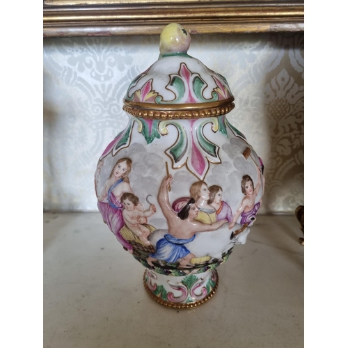 138 - A good pair of hand painted Urns with lids depicting Maidens and Cherubs playing. With gold outline.... 