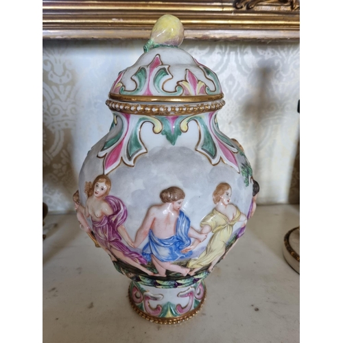 138 - A good pair of hand painted Urns with lids depicting Maidens and Cherubs playing. With gold outline.... 