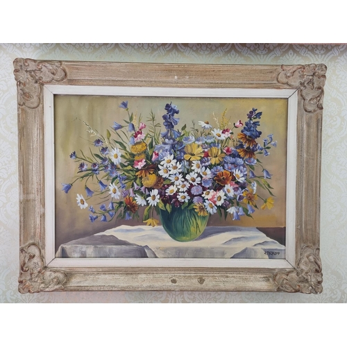 189 - A 20th Century Oil on Canvas still life of wild flowers in a vase on a table setting. Indistinctly s... 