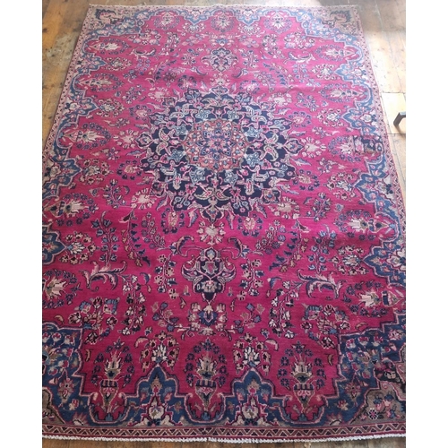 821 - A Red ground Persian Carpet with a unique medallion design surrounded with a unique river blue borde... 