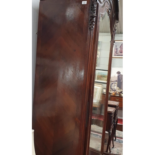 399 - A 19th Century Rosewood and Veneered single door Armoire with highly carved outline and bevelled mir... 