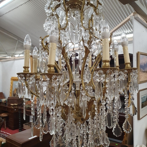 446 - A Magnificent eight branch Brass and Crystal Chandelier profusely decorated with drop crystals. Drop... 