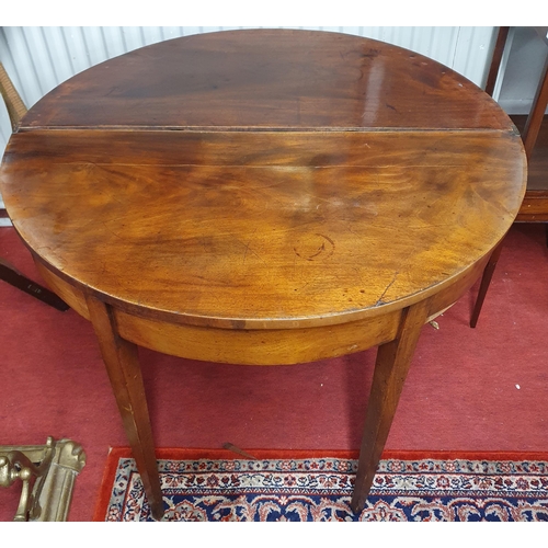 834 - A Georgian Mahogany bow fronted fold over Tea Table of simple form with square tapered supports.  D ... 