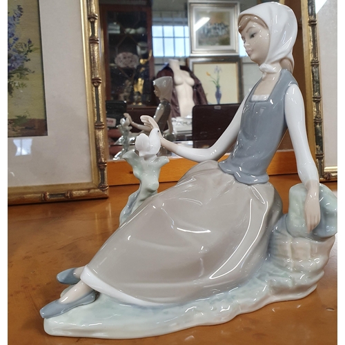 883 - A Lladro Figure of a Girl with a dove beside. H 17 cm approx.