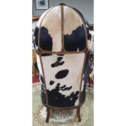 1083 - An unusual and quirky Porters Chair with hide upholstery and heavy deep buttoned outline on carved c... 