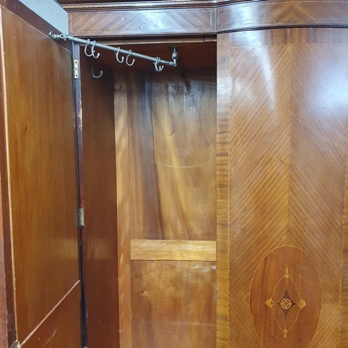 693 - An Edwardian Mahogany Inlaid and veneered two door wardrobe with a bow fronted centre panel flanked ... 