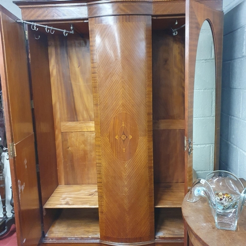 693 - An Edwardian Mahogany Inlaid and veneered two door wardrobe with a bow fronted centre panel flanked ... 