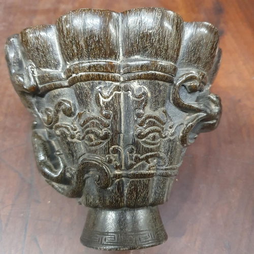 464 - An unusual carved Chinese faux rhino horn Libation Cup carved with mythical figures and with forecas... 