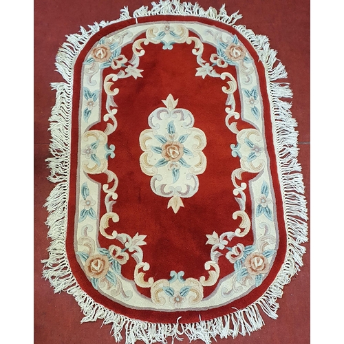 518 - An Oval red ground Oriental style rug. 160 x 110 cm approx.