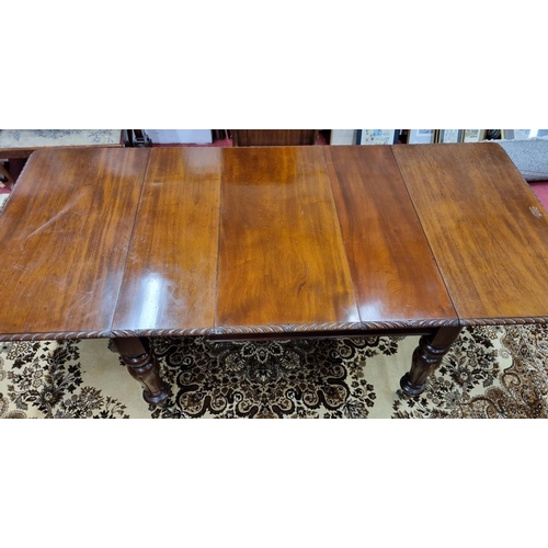 19 - A 19th Century Mahogany three leaf Dining Table with roped moulded edge on a carved tulip bulbous su... 