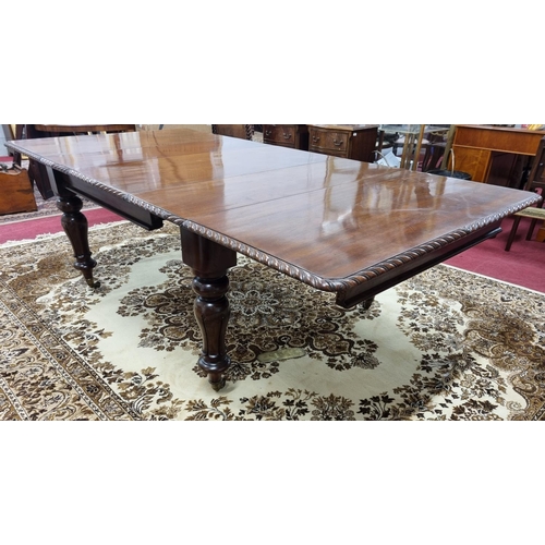 19 - A 19th Century Mahogany three leaf Dining Table with roped moulded edge on a carved tulip bulbous su... 