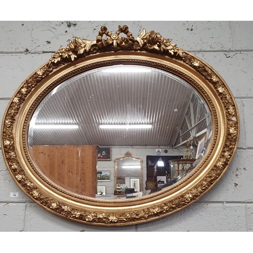 76 - A good Timber and Plaster Gilt oval Mirror with highly carved cartouche top and bevelled mirror glas... 