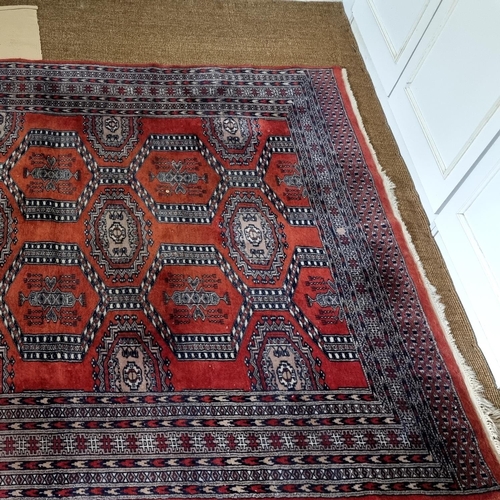 202 - A good red ground Rug with repeating central medallion design and multi borders. 253 x 155cm approx.