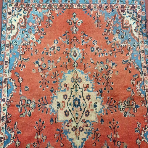 208 - A Red ground Persain Rug with a unique medallion design and multi borders. 243 x 162cm approx.