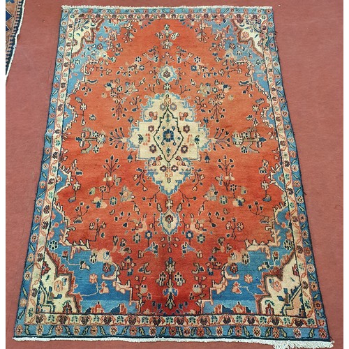 208 - A Red ground Persain Rug with a unique medallion design and multi borders. 243 x 162cm approx.