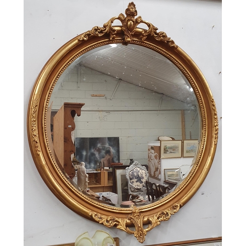 257 - A large Timber and Plaster Gilt circular Mirror with bevelled glass and carved cartouche top and bot... 