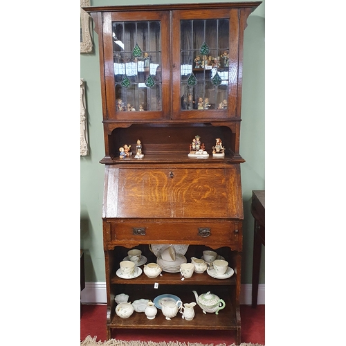 111 - An early 20th Century Arts and Crafts Oak bureau with stained glass glazed upper and fitted interior... 