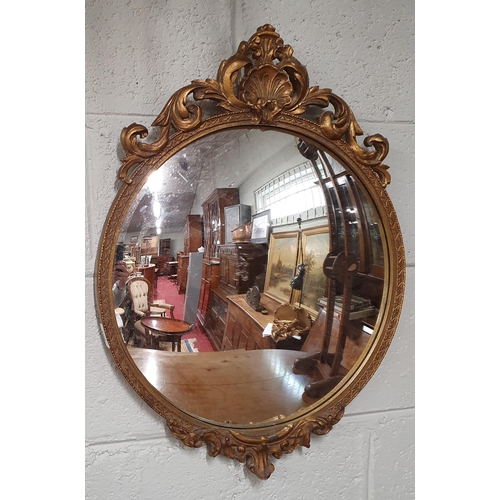 106 - An early 20th Century Plaster and Gilt circular Mirror with cartouche carved top and convex glass. 4... 