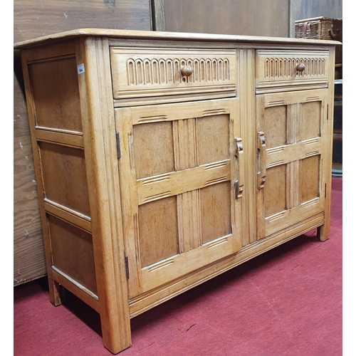 564 - A Mid Century Oak two door Cabinet with twin frieze drawer. 120 x 45 x H 86 cm approx.