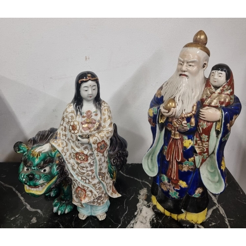 886 - A Chinese porcelain group depicting a woman patting a foo dog together with another with an old man ... 