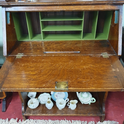 111 - An early 20th Century Arts and Crafts Oak bureau with stained glass glazed upper and fitted interior... 