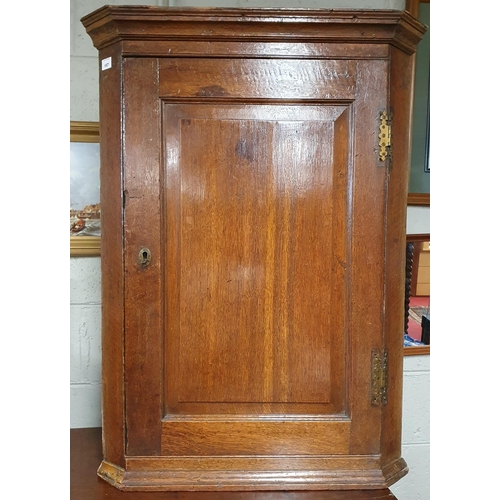 157 - An early 19th Century Oak Wall hanging corner Cabinet with brass mounted hinges. W 65 x H 93 cm appr... 