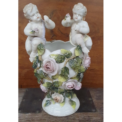 220 - A German Porcelain Pot with hand painted decoration of roses and seated cherubs. H 19 cm approx.