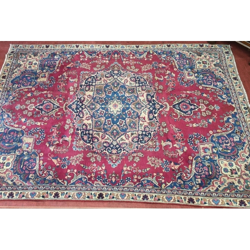 895A - A Red and Blue ground Iranian Carpet with a central lozenge medallion from the Tabriz region of Iran... 