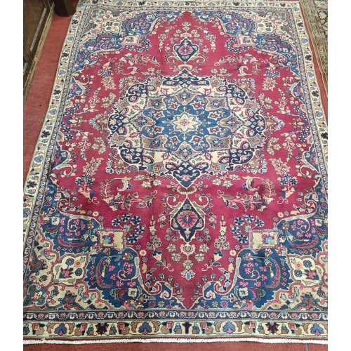 895A - A Red and Blue ground Iranian Carpet with a central lozenge medallion from the Tabriz region of Iran... 