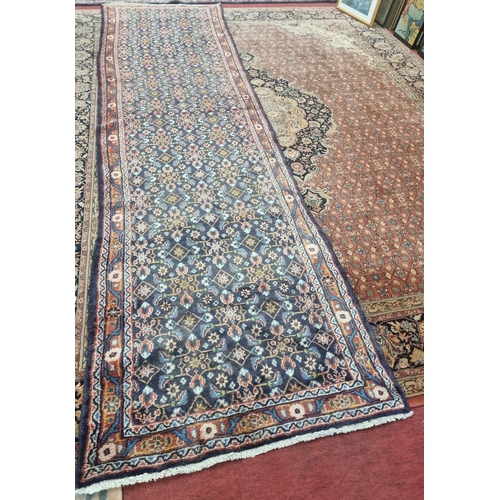 247 - A large and long deep Blue ground Persian Sarouk Runner with an all over pattern design. 410 x 141cm... 