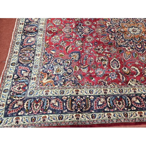 500 - A rich Red ground Iranian Carpet with a central medallion design surrounded with a rich border from ... 