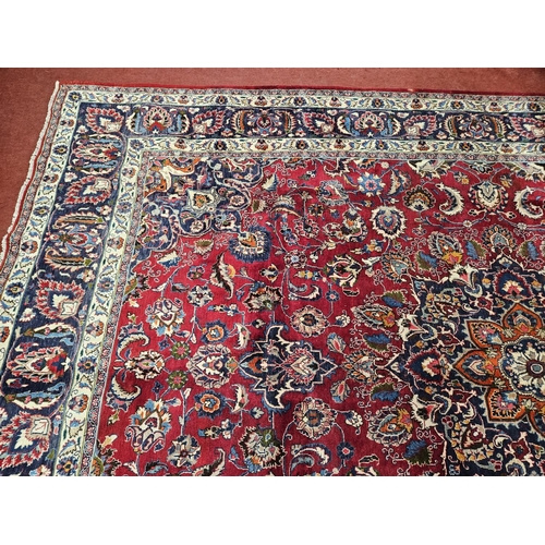 500 - A rich Red ground Iranian Carpet with a central medallion design surrounded with a rich border from ... 