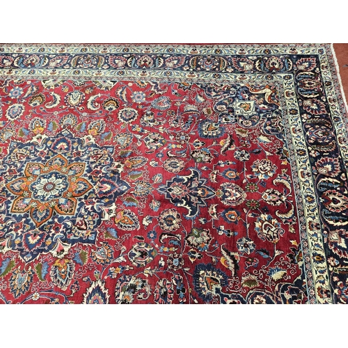 500 - A rich Red ground Iranian Carpet with a central medallion design surrounded with a rich border from ... 