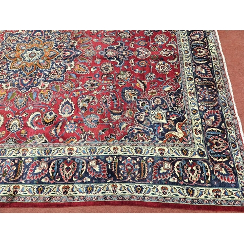 500 - A rich Red ground Iranian Carpet with a central medallion design surrounded with a rich border from ... 