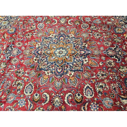 500 - A rich Red ground Iranian Carpet with a central medallion design surrounded with a rich border from ... 